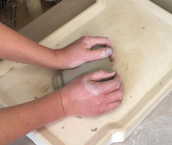 Wedging clay to prepare for making pottery