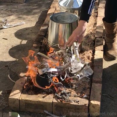 adding paper to the flames and pots