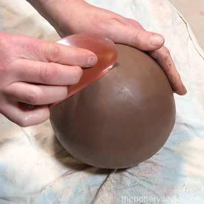 smoothing the pinch pot vase