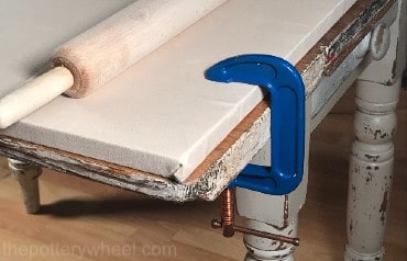 clay rolling board clamped to table