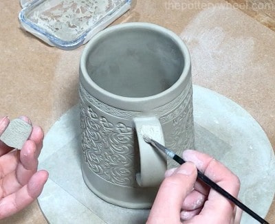 applying slip to handle on slab built mugs