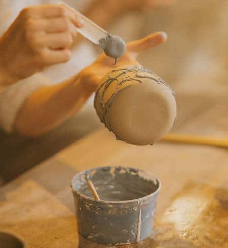 Applying slip to greenware pottery