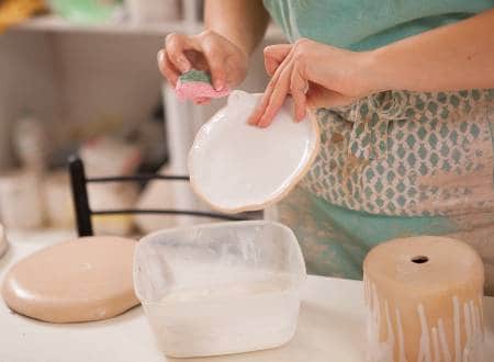 applying glaze to pottery to make it food safe