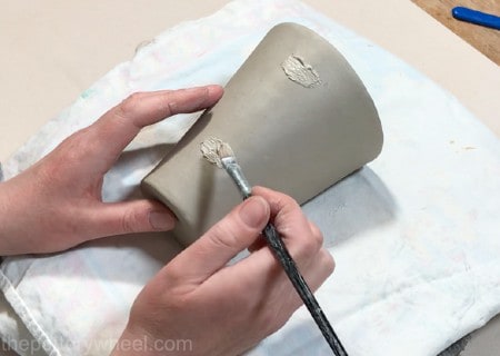 applying slip onto clay