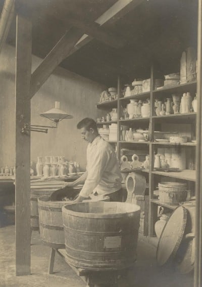 Potter applying tin glaze to Delft pottery