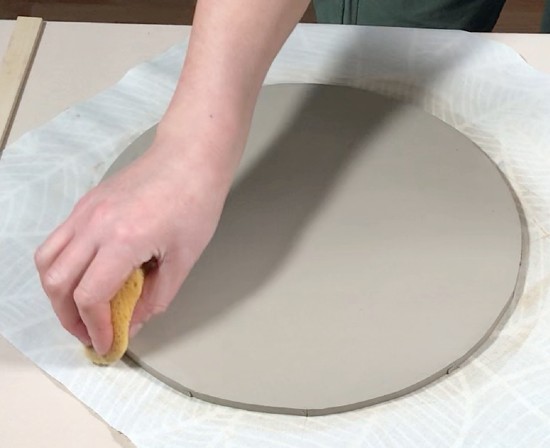 smoothing down the edge of the ceramic clock