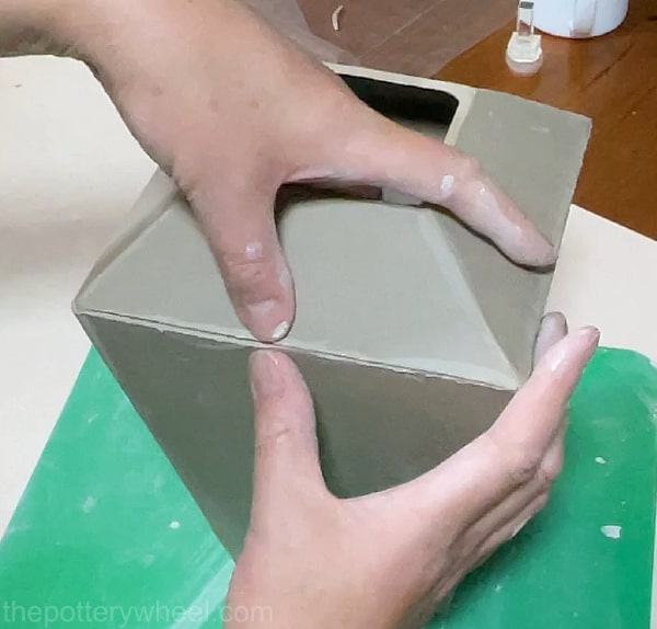 adding the shoulder to the clay vase