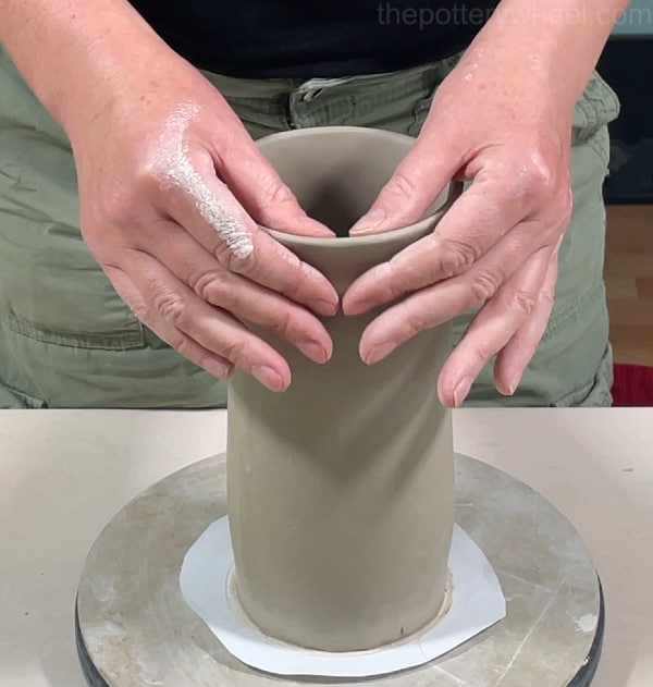Curving the rim of the clay vase