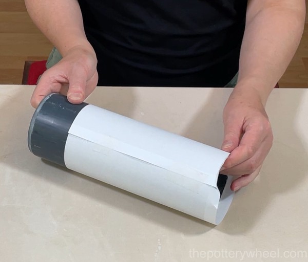 Wrapping the plastic tube in paper
