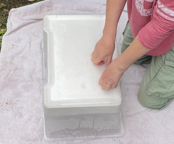 pressing the plaster slab for drying clay out of the container