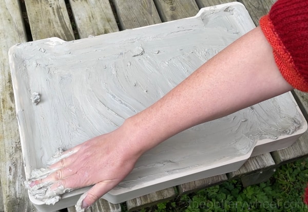 Spreading clay slip on the plaster slab