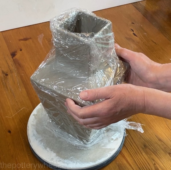 wrapping clay vase in saran wrap