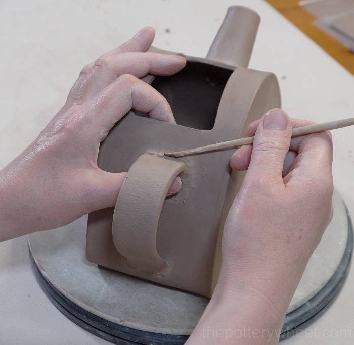 blending a coil on the slab pottery teapot handle