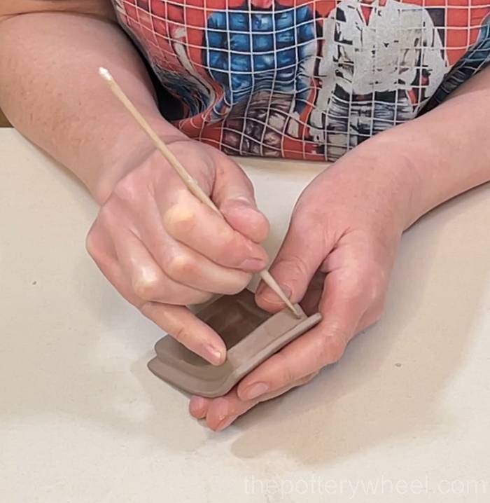 trimming the rim of the slab pottery teapot