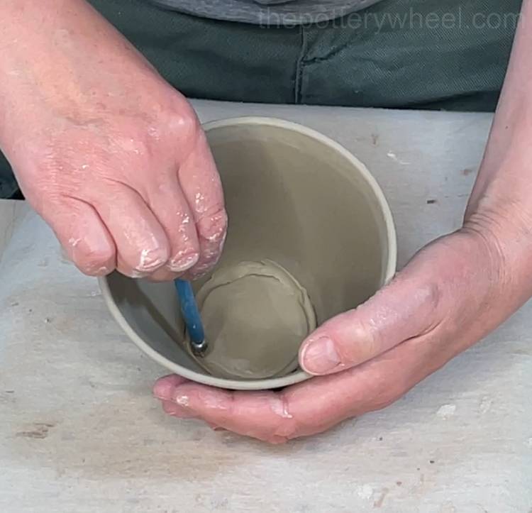 smoothing the clay coil in the base of the mug