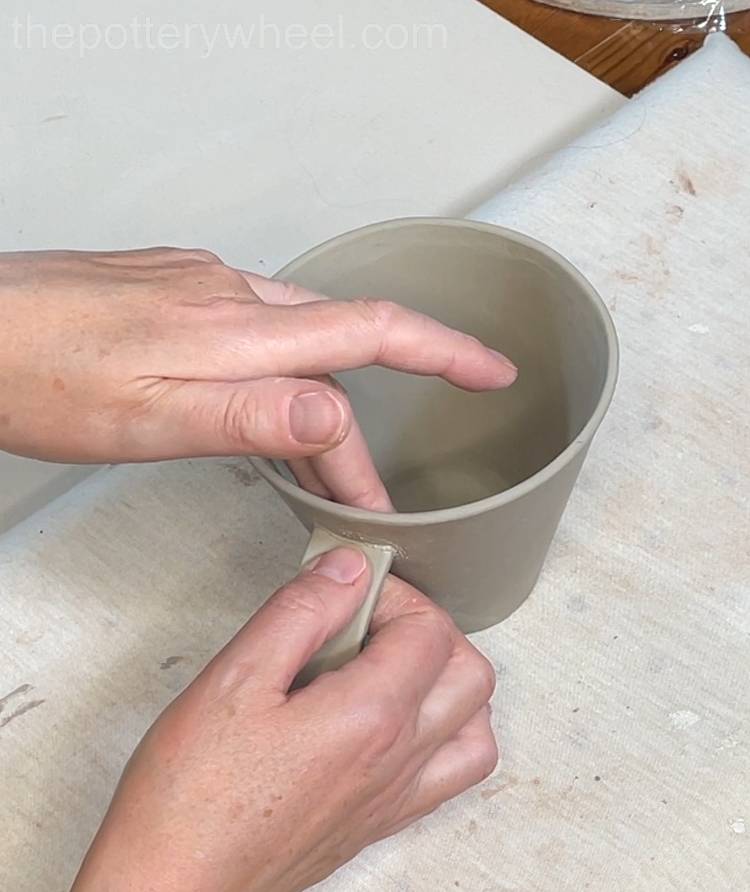 pressing the handle onto the mug