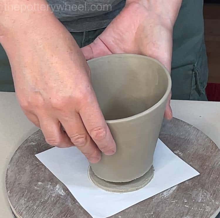 lowering the mug onto the base