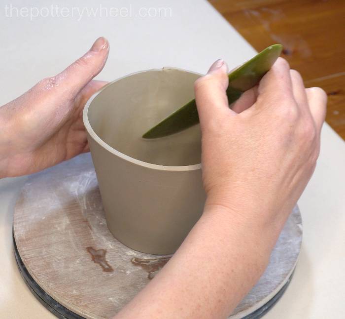 Smoothing the square bottomed slab mug with a platter tool