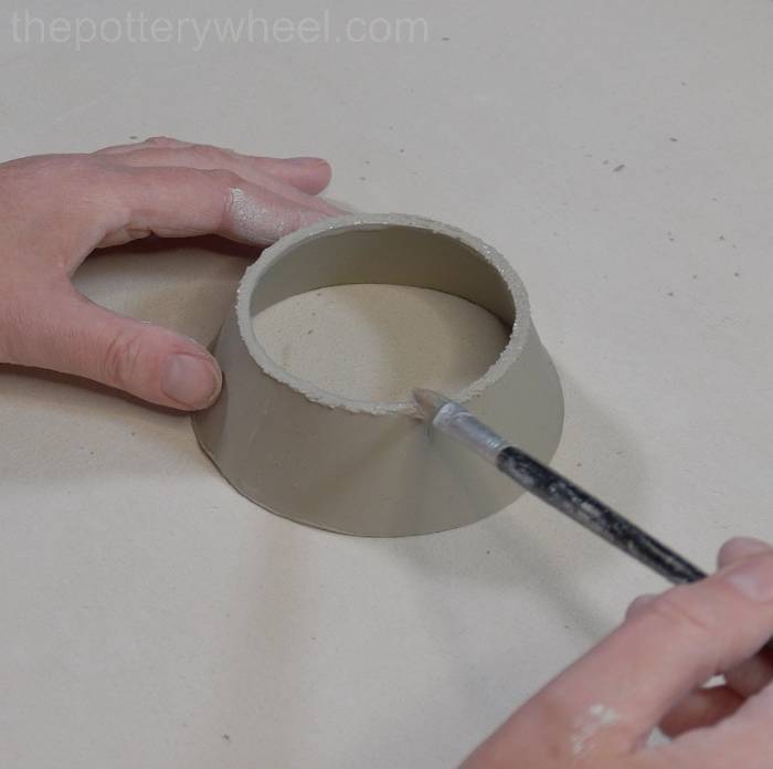 applying slip to the base of the mug