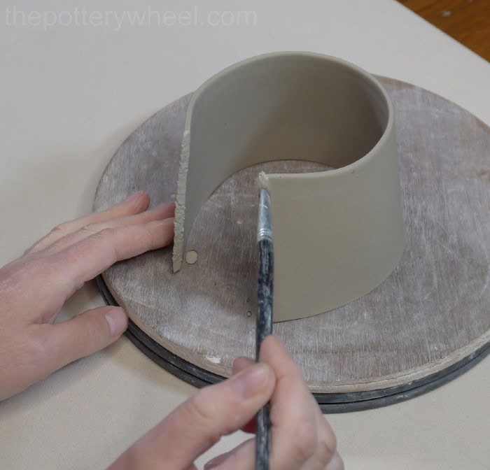 putting slip on the edge of the clay