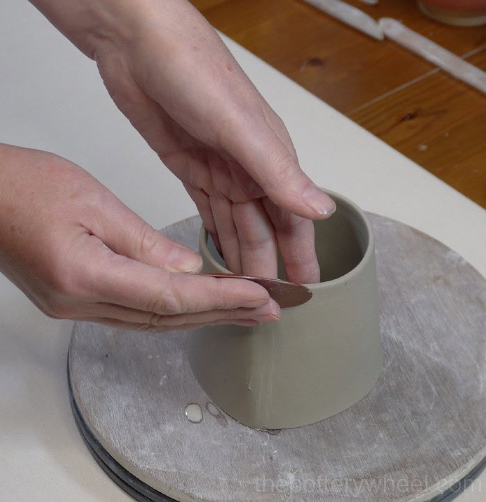 smoothing the seam of the bellied slab mug with a rib