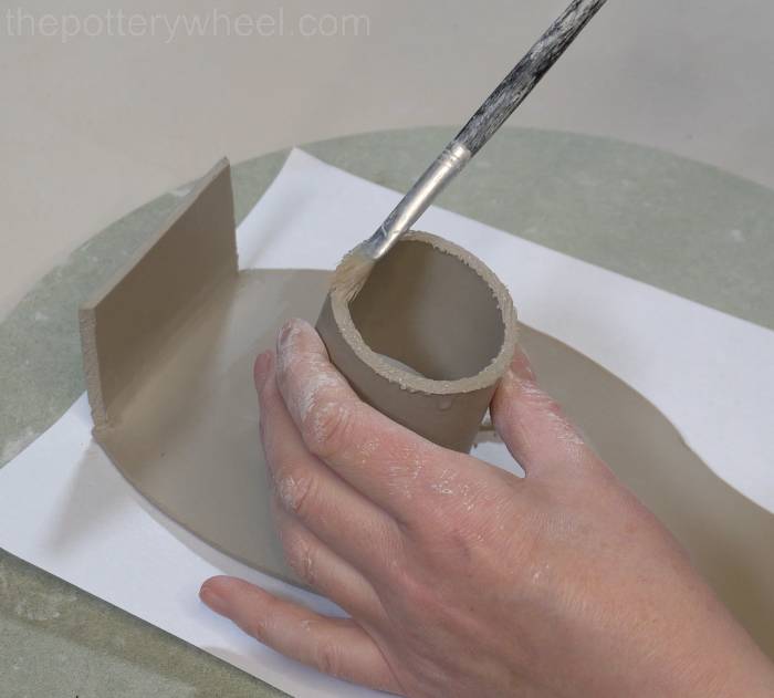 applying slip to the scored clay