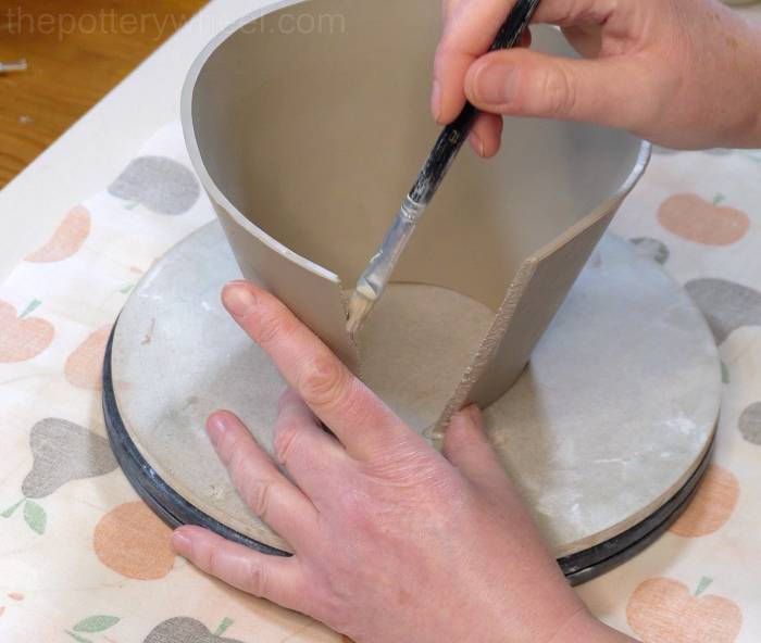 applying slip to the edge of the clay