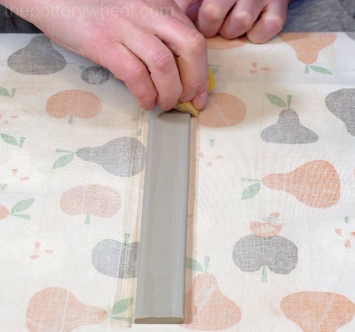 smoothing the edge of the handle of the jug