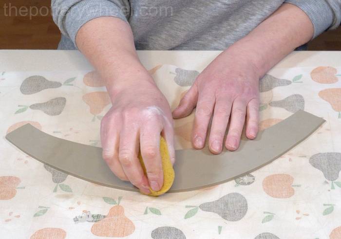 smoothing the rim of the jug