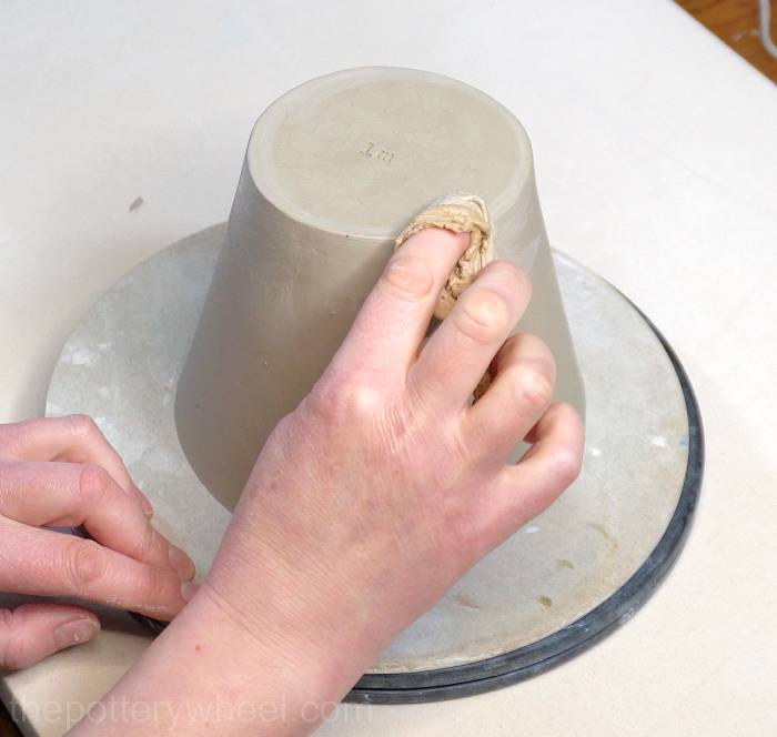 tidying up the base of the jug with a chamois leather