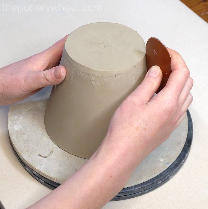 tidying up the base of the jug with a rubber pottery rib