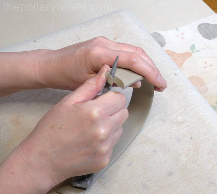 trimming the end of the handle of the jug