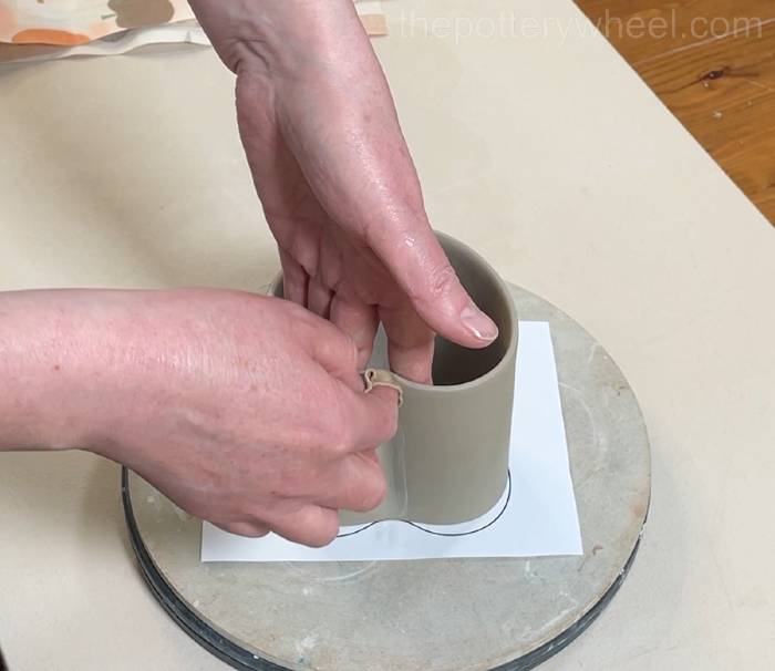 Shaping the clay cylinder into a heart shaped slab pottery mug