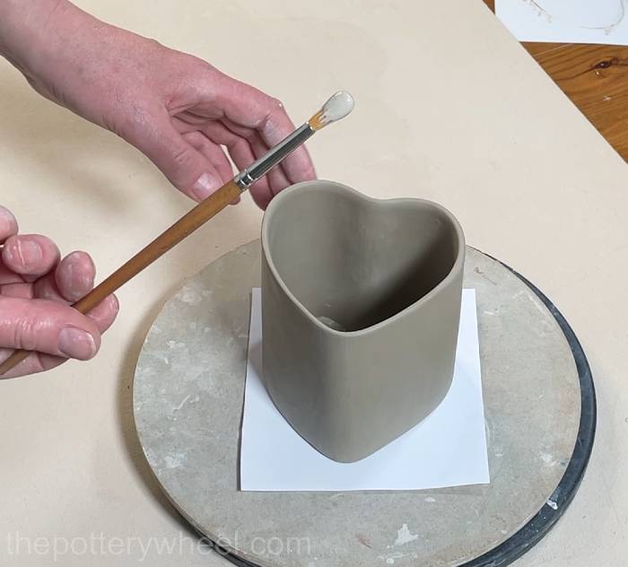loading clay slip onto a brush