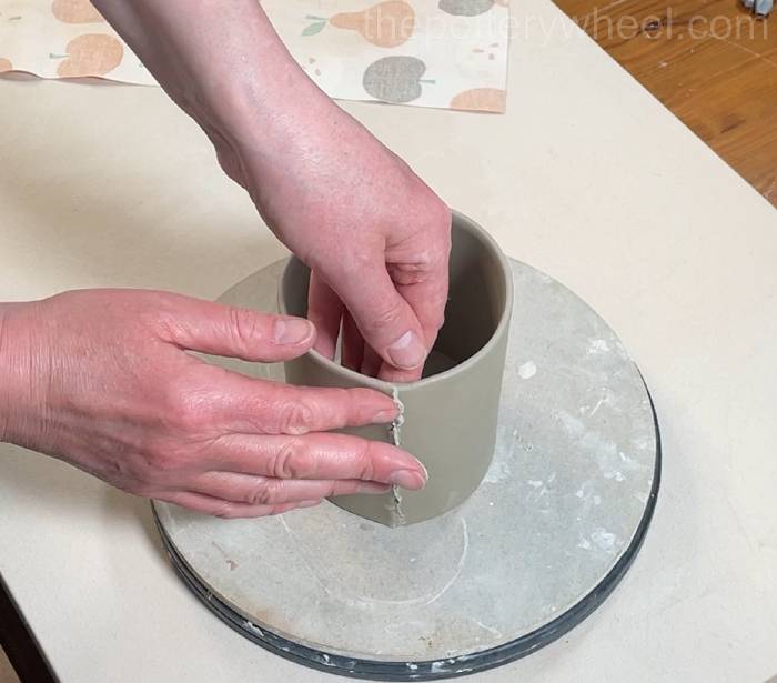 pressing the edges of the clay slab together