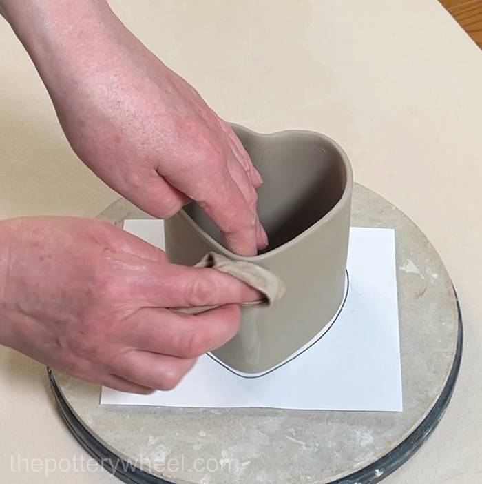 smoothing small cracks in the surface of the heart shaped slab mug