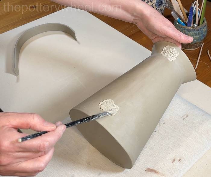 applying slip to the side of the vase