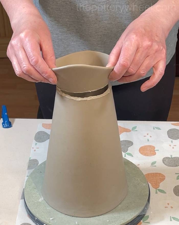 lowering the rim of the flower jug vase onto the base