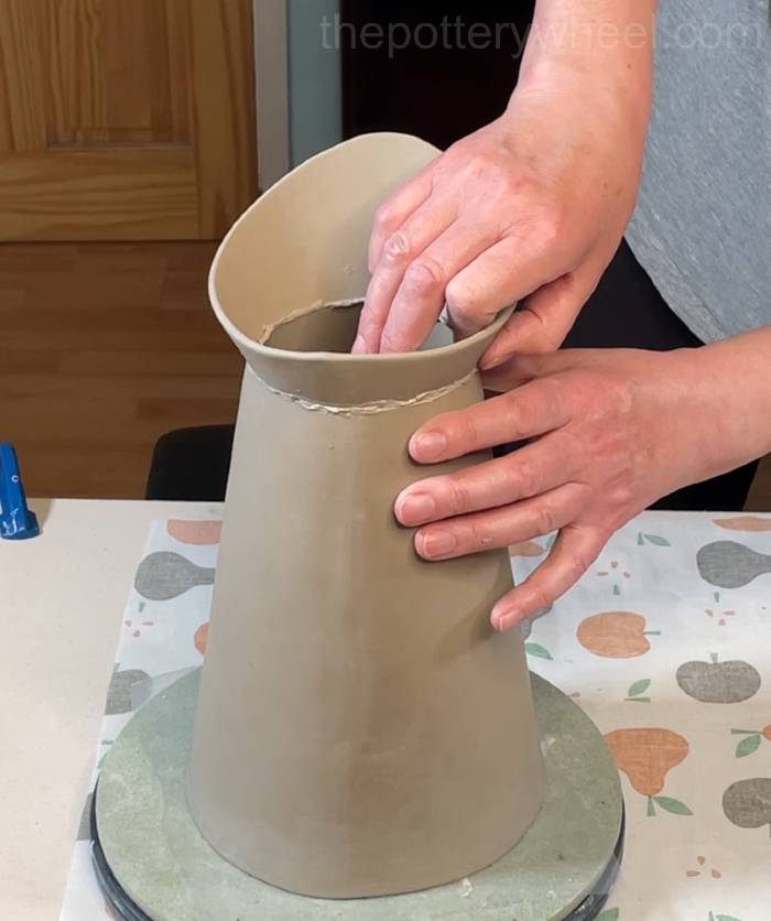 pressing the rim onto the base of the flower jug vase