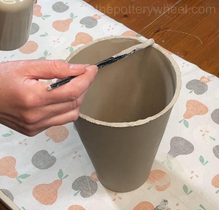 putting slip on the bottom edge of the flower jug vase