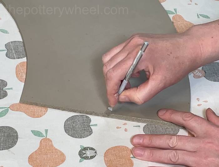 scoring the edge of the clay slab
