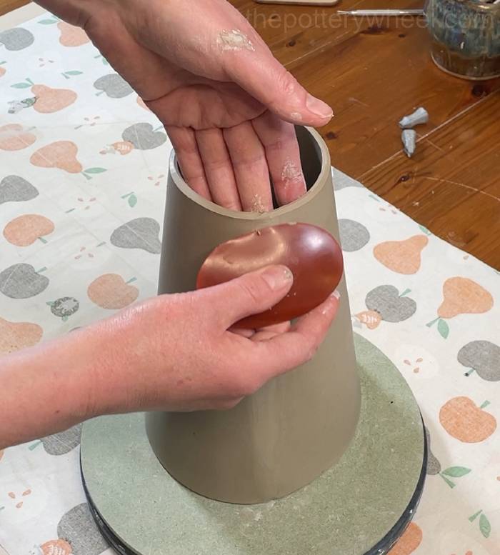 smoothing the side of the flower jug vase