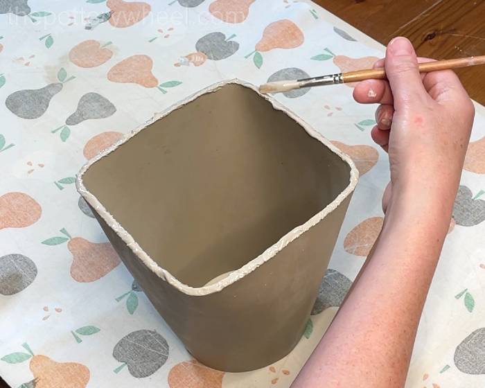 Applying clay slip to the scored surfaces