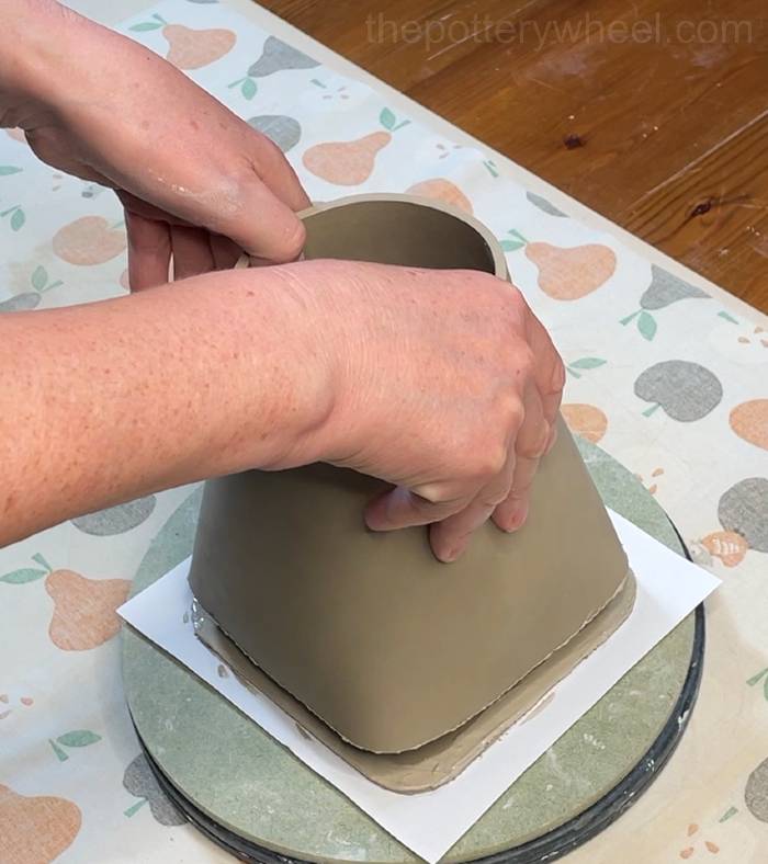 Lowering the square-based teapot onto the base