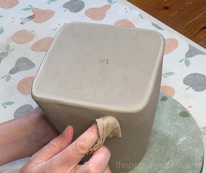 Wiping the square-based teapot down