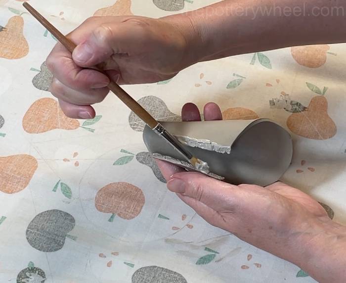 applying slip to the scored edge