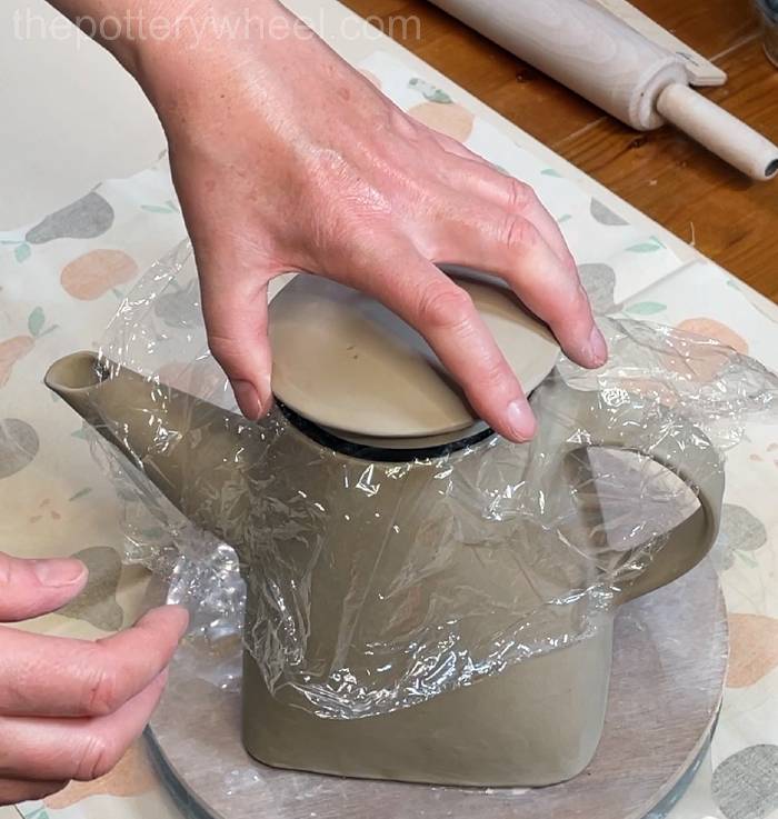 lowering the lid onto the square-based teapot