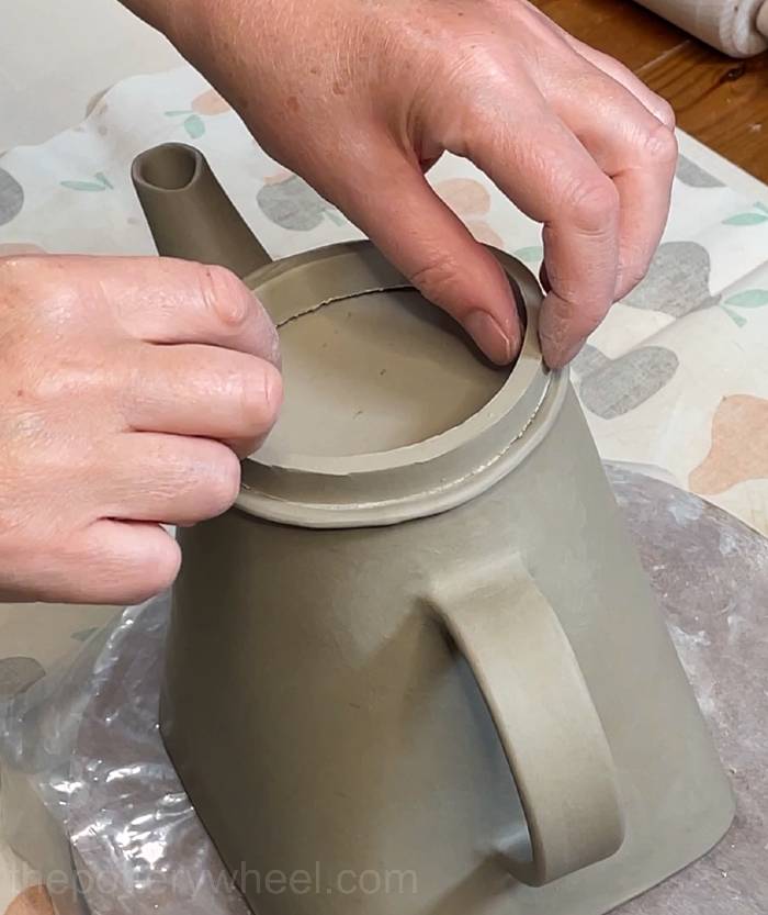 positioning the rim on the teapot lid