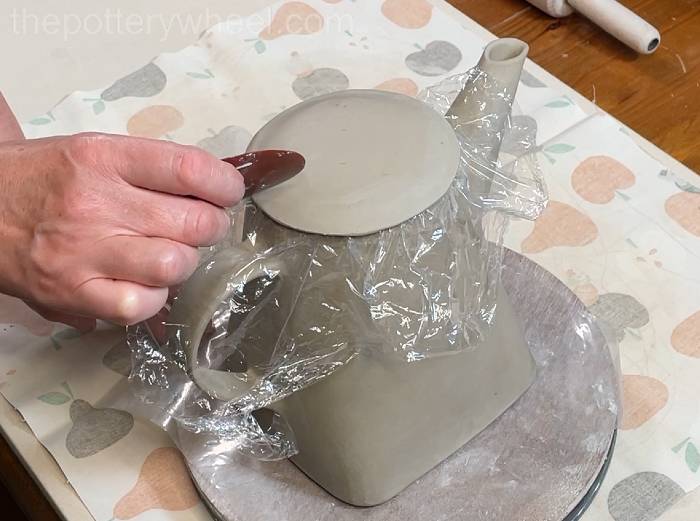 smoothing down the lid of the teapot