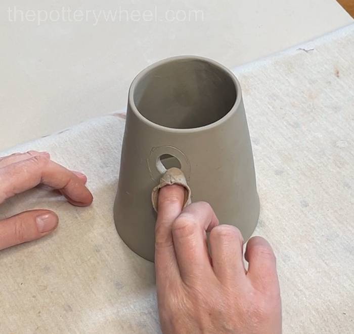 Tidy up the edge of the hole in the clay